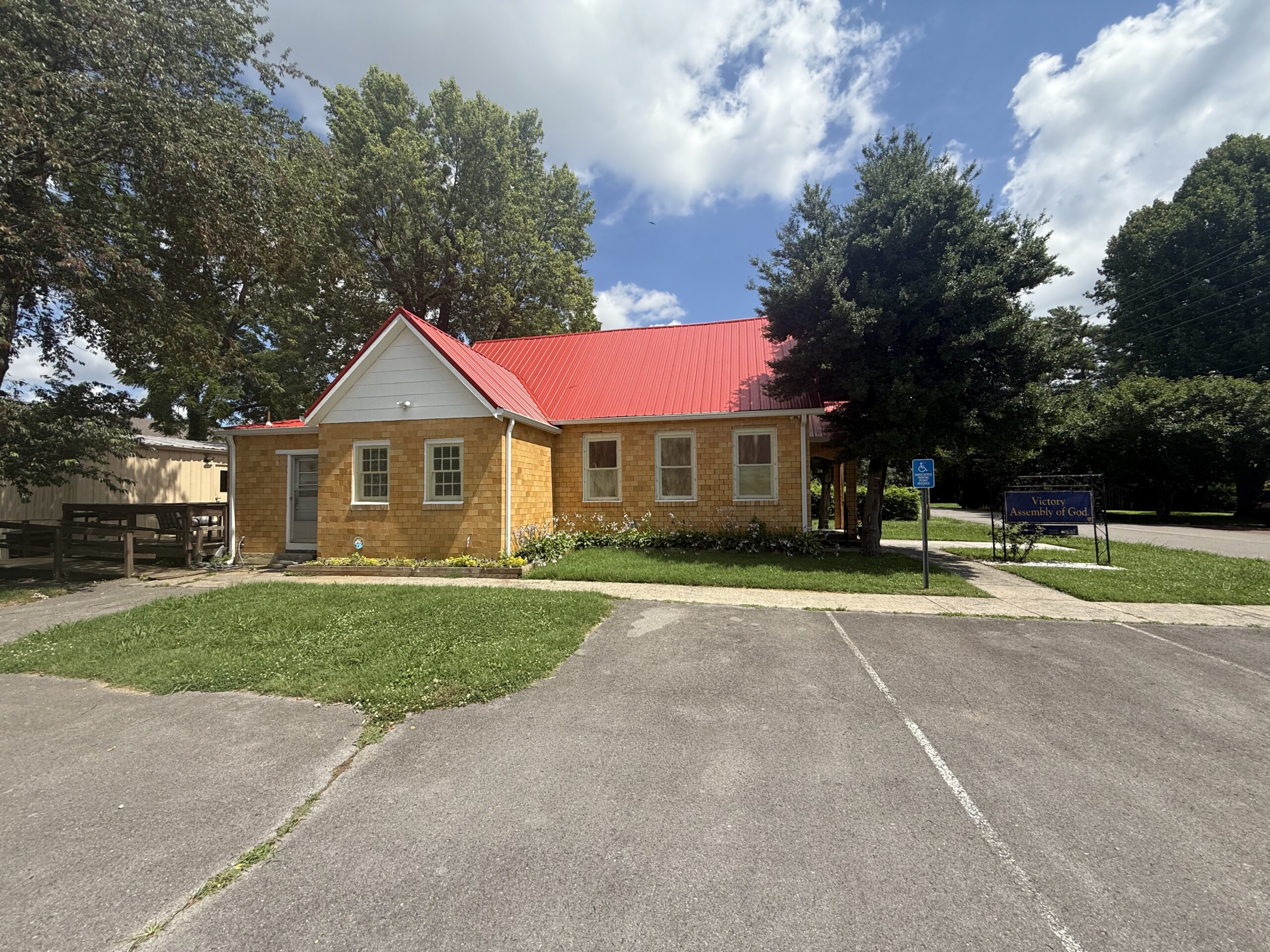 A small brick church with a red roof